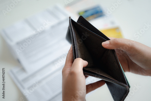 Symbolic Representation of Financial Situation, empty wallet lying on a paper bill and a credit card