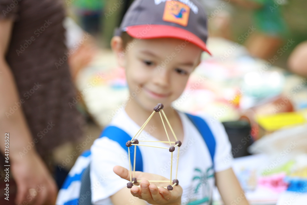 Boy holding a toy house. Concept: mortgage, purchase, sale of real estate, rental housing.