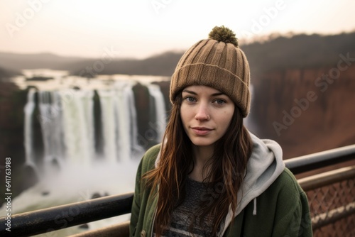Conceptual portrait photography of a tender girl in her 20s wearing a trendy beanie at the iguazu falls argentina-brazil border. With generative AI technology