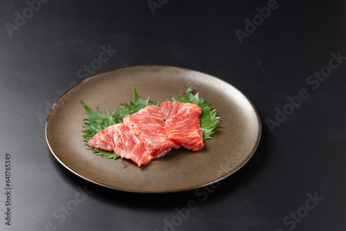 Rare Sliced Wagyu beef with marbled texture. Japanese and korean rare beef for grilled on black plate food isolated on gray stone banner background
