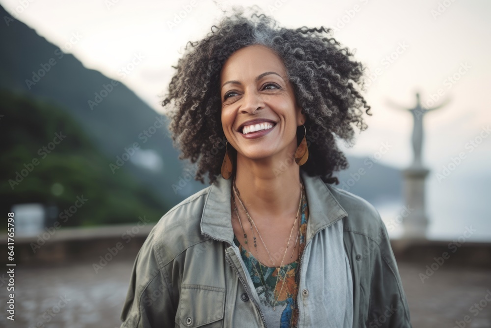 Medium shot portrait photography of a blissful mature woman wearing a trendy bomber jacket at the christ the redeemer in rio de janeiro brazil. With generative AI technology