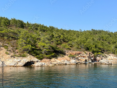 Aegean sea near Ayvalik, Cunda. Sea side summer holidays. Charming bay near Cunda island in Aegean sea, crystal clear water surrounded by rocks. Blue sky, turquoise blue water, vacations, summertime