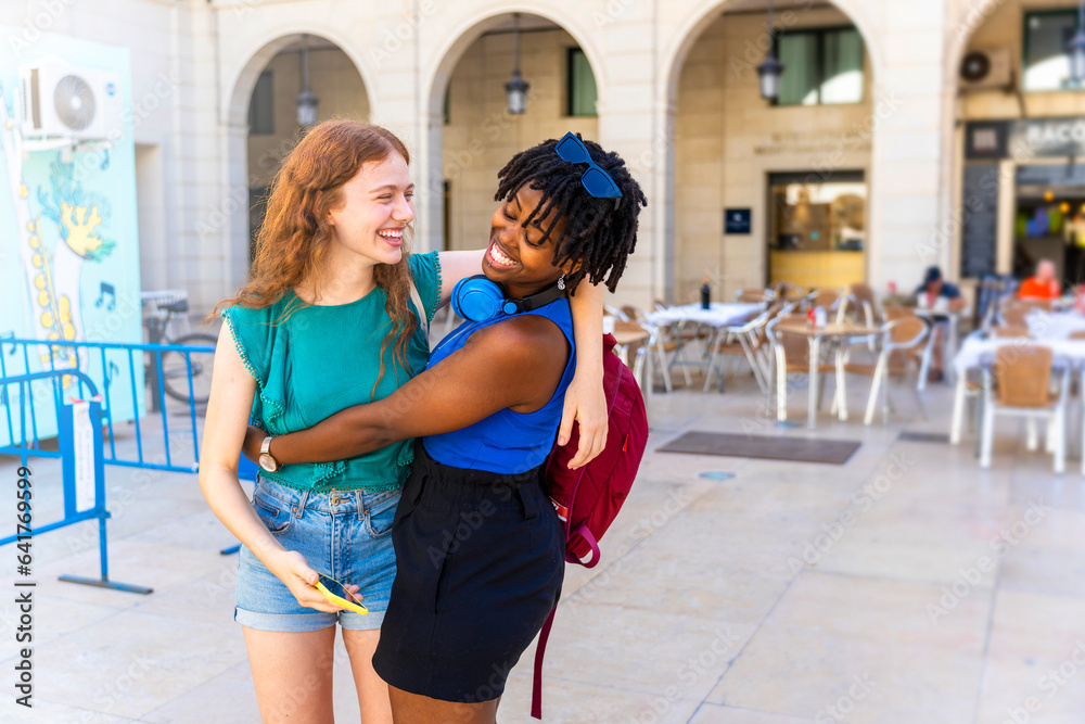 Obraz premium Interracial and multicultural friendship. Two friends hugging, happy and happy.