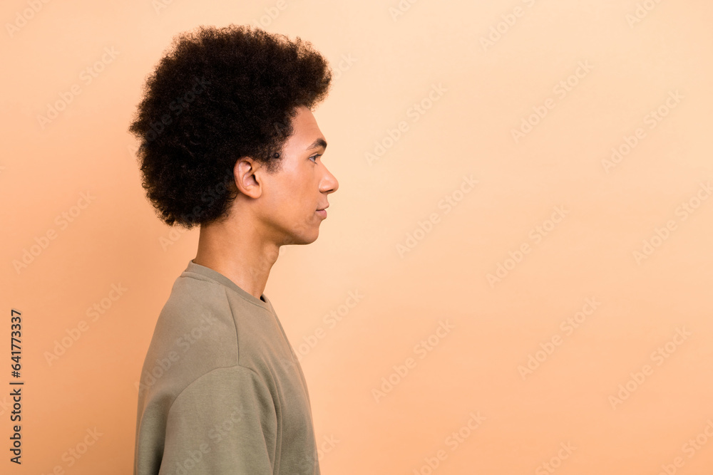 Side profile photo of good mood pleasant guy with afro hairstyle wear khaki shirt look empty space isolated on beige color background Side profile photo of good mood pleasant guy with afro hairstyle wear khaki shirt look empty space isolated on beige color background