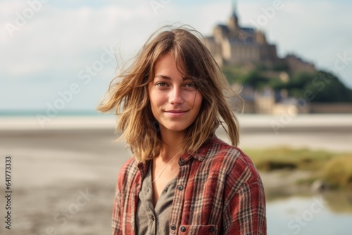 Environmental portrait photography of a blissful girl in her 30s wearing a comfy flannel shirt at the mont saint-michel in normandy france. With generative AI technology