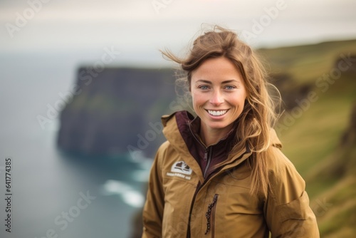 Environmental portrait photography of a jovial girl in her 40s wearing a stylish varsity jacket at the cliffs of moher in county clare ireland. With generative AI technology
