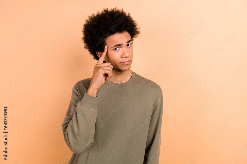 Photo of optimistic clever thoughtful guy with afro hairstyle wear khaki shirt hold finger on head isolated on beige color background Photo of optimistic clever thoughtful guy with afro hairstyle wear khaki shirt hold finger on head isolated on beige color background