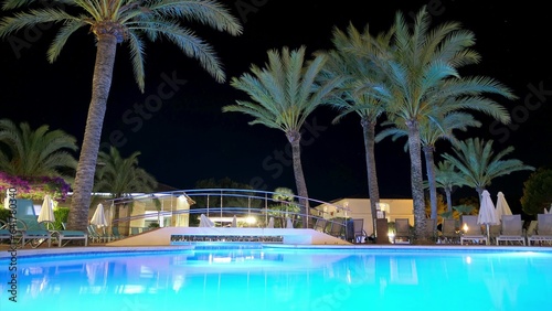 Tropical Resort Swimming Pool and Palm Trees at Night Time Lapse