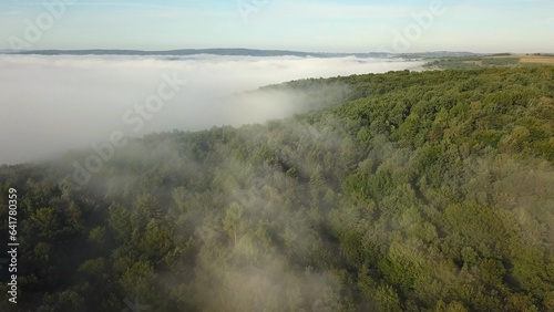Aerial of Forest and Hills Covered with Fog at Sunrise