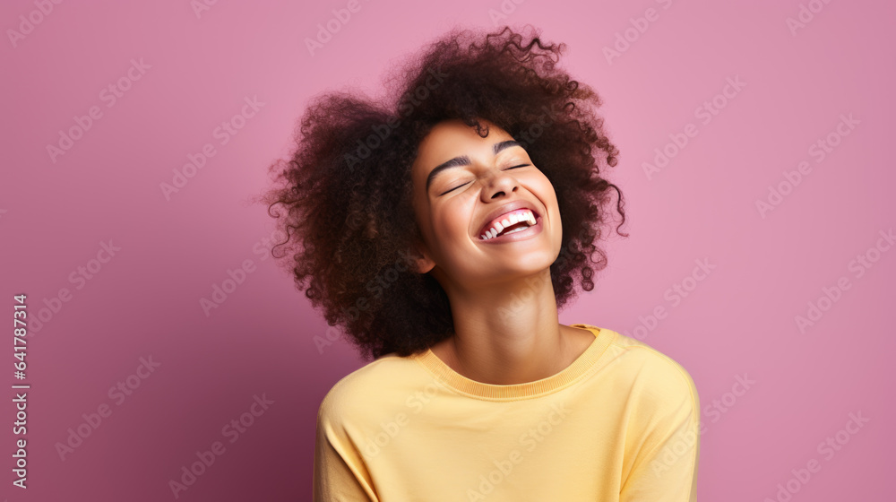Young woman laughs against a pink background. Young woman laughs against a pink background.