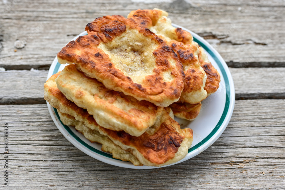 Traditional Bulgarian home made deep fried  patties  covered with sugar  оn rustic backgroud.Mekitsa or Mekica,  on wooden  rustic  background. Made of kneaded dough that is deep fried 
