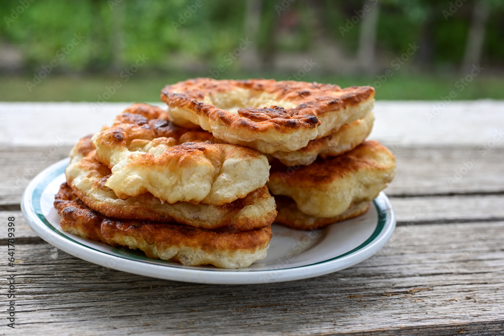 Traditional Bulgarian home made deep fried  patties  covered with sugar  оn rustic backgroud.Mekitsa or Mekica,  on wooden  rustic  background. Made of kneaded dough that is deep fried 