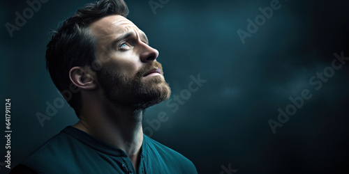 man's soulful gaze, capturing an air of mystery, against a dark teal background