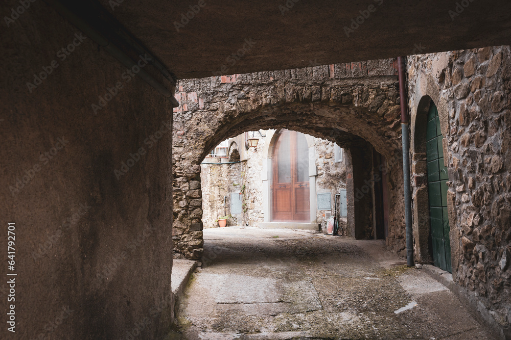 a narrow street with typical architecture in Ponzanello medieval village, Municipality of Fosdinovo, province of Massa-Carrara, Tuscany, Italy - obrazy, fototapety, plakaty 