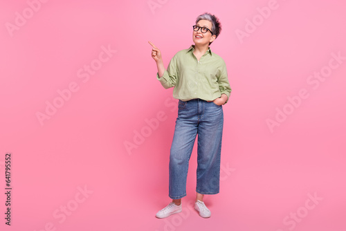 Full body length photo of middle age businesswoman demonstrate empty space information useful tips isolated on pink color background