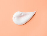 White skincare cleansing foam on peach background