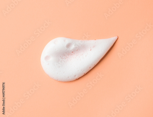 White skincare cleansing foam on peach background