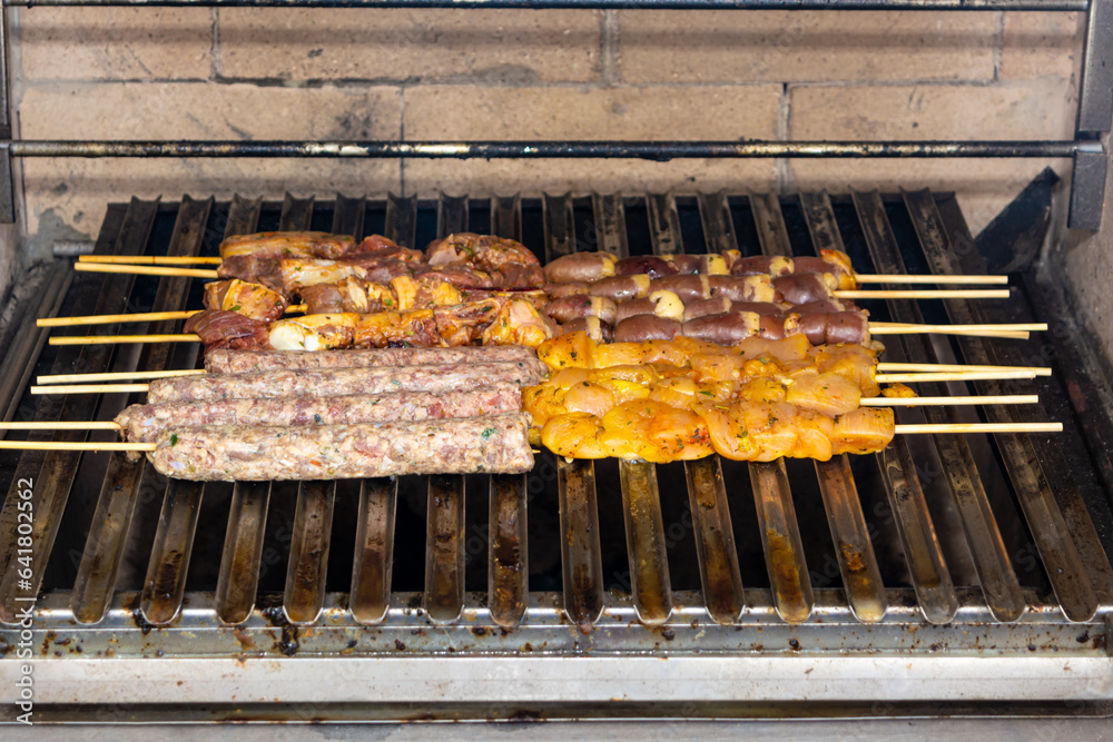 grilling meat skewer, traditional brazilian barbecue with meat on skewer known as espetinh or churrasquinho