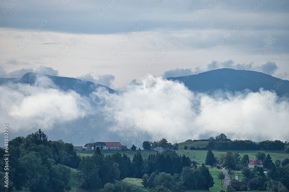 typical autumn landscape with low clouds and mountain peaks in the background typical autumn landscape with low clouds and mountain peaks in the background