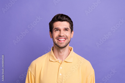 Photo of dreamy funky man dressed yellow shirt looking up empty space isolated purple color background