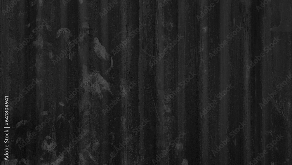 old dark black galvanized corrugated metal sheet wall with rust used as background in close up view. grey rusty iron metal construction site wall. old dark black galvanized corrugated metal sheet wall with rust used as background in close up view. grey rusty iron metal construction site wall.