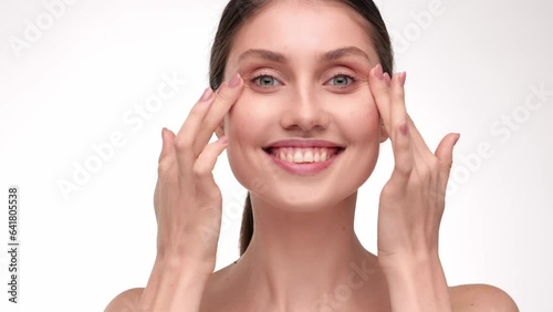 Close up portrait female uses creams of her face. Concept for fresh moisturized skin beautiful close up cosmetic face happy healthy model. Brunette hair woman take care of her skin. Cosmetic Concept.