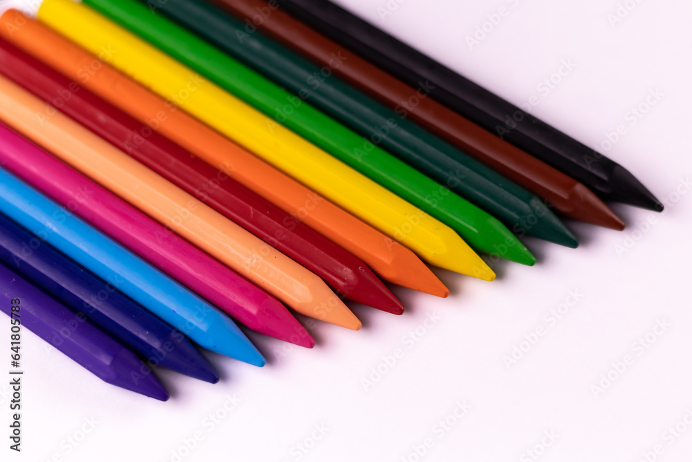 Fototapeta premium High angle closeup shot of colorful crayons on white background -Play school concept.