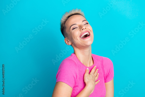 Photo portrait of pretty young girl laughing arm touch chest have fun dressed stylish pink outfit isolated on cyan color background