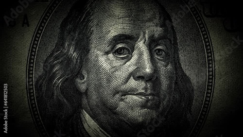 The portrait of Benjamin Franklin on the 100 US dollar bill is a close-up that gradually darkens and the eyes begin to glow. The idea of a conspiracy theory. 4k concept video.