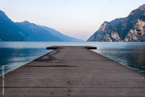 Fototapeta Naklejka Na Ścianę i Meble -  Wooden pier on the lake Garda against the backdrop of the mountains