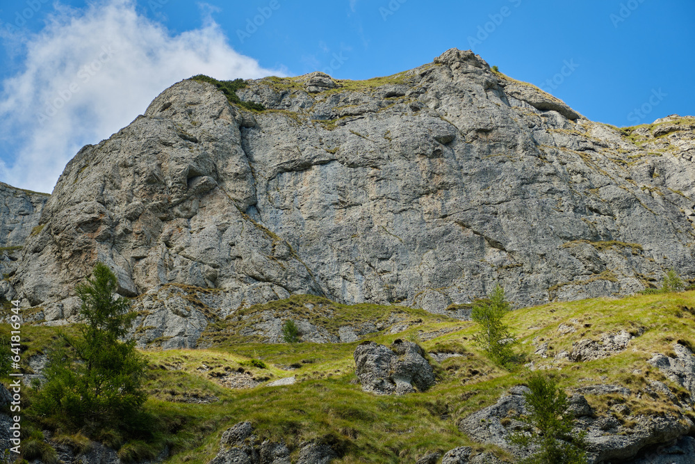 Beautiful mountain terrain in Bucegi National Park  Mountain landscape with green meadow and sharp rocks.
