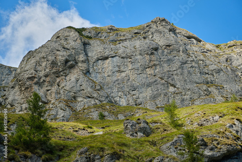 Beautiful mountain terrain in Bucegi National Park Mountain landscape with green meadow and sharp rocks.
