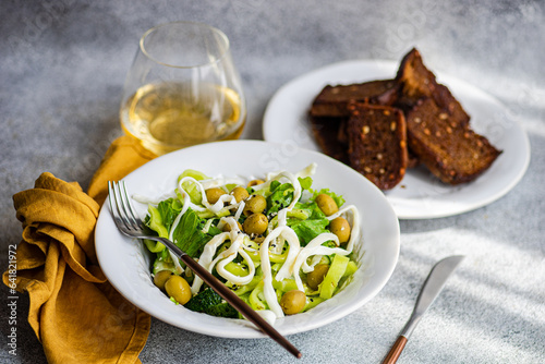 Vegetable salad with green vegetables like lettuce, cucumber, olives, green bell pepper with homemade cheese, sesame seeds photo