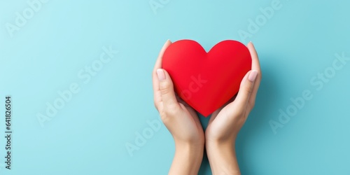 Young women hands holding red heart on light blue background  health care  donate and family insurance concept  world heart day  world health day  CSR responsibility  generative ai
