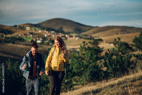Couple of hikers walking on a mountain trail during a vacation