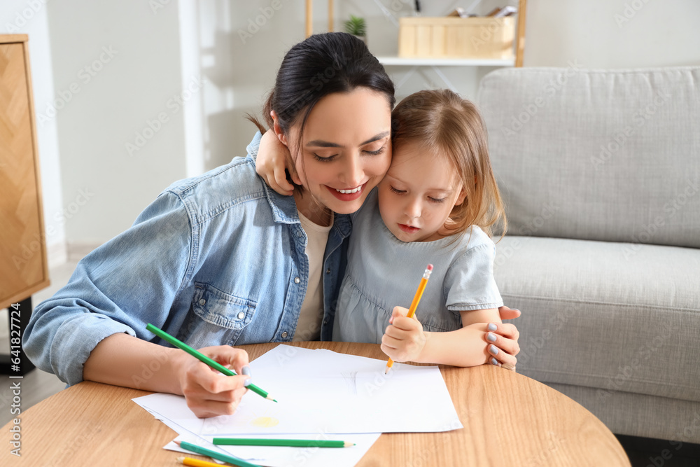 Young woman with her little daughter drawing at home Young woman with her little daughter drawing at home