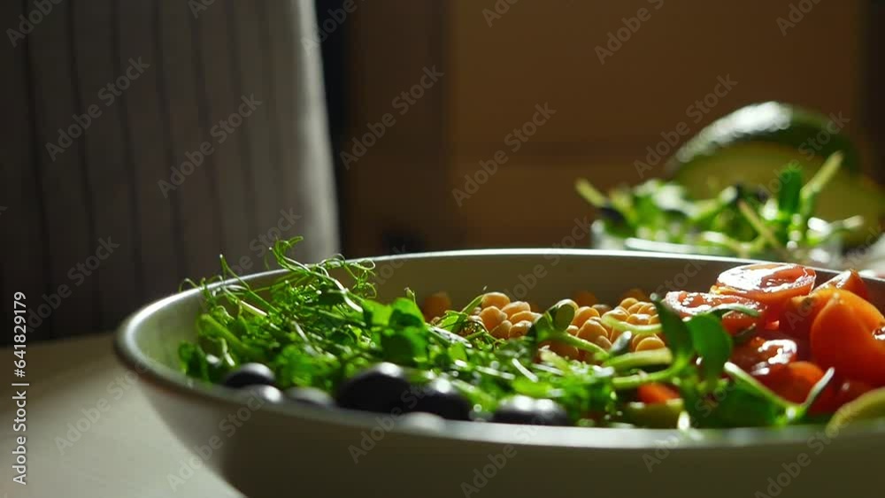 super slow motion video of microgreens falling on a plate full of colorful vegetables. healthy eating ingredients, cooking healthy bowl recipes 1000 fps, 