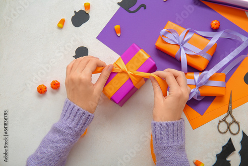Hands tying orange ribbon o...