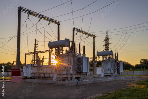 High voltage transformer and rays of the morning sun. Illumination from sunrise.