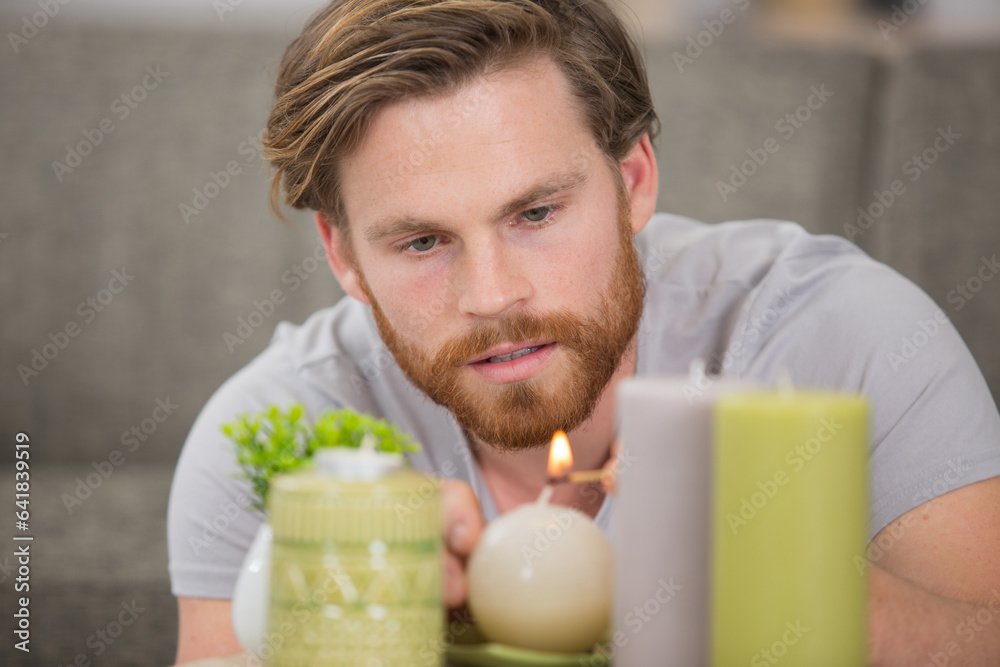 man lighting candles for romance at home man lighting candles for romance at home
