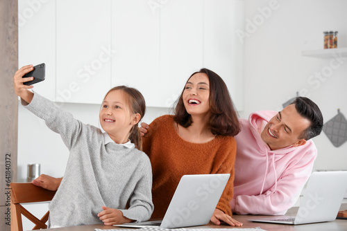 Happy family with laptops a...