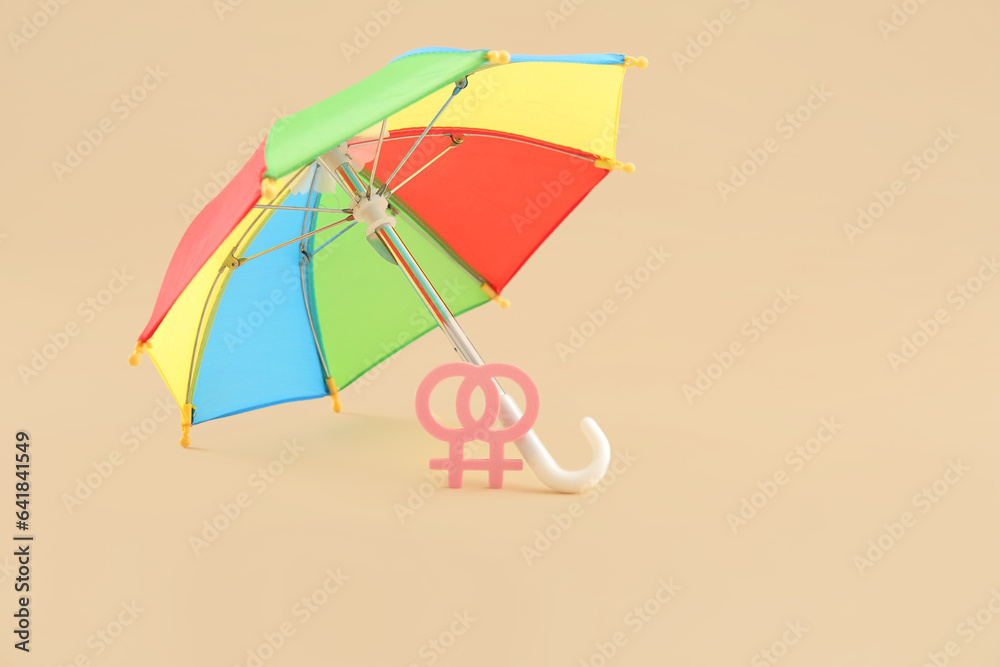 Lesbian symbol with rainbow umbrella on beige background. LGBT concept