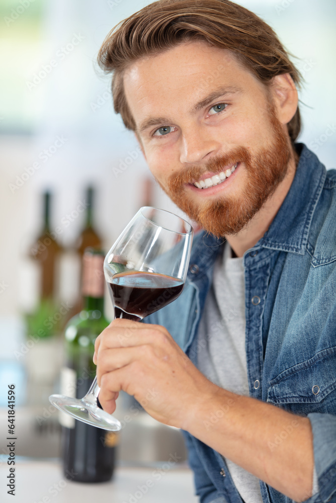 man tasting a glass of red wine at home man tasting a glass of red wine at home