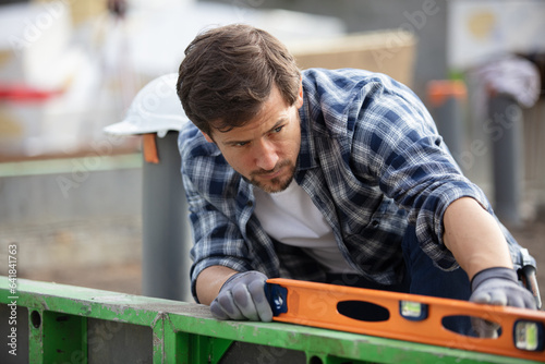 man holding spirit level at construction site