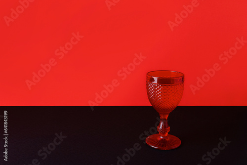 Wineglass on double red black background. Halloween black friday sale concept photo