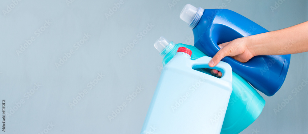 Hand taking blue liquid soap bottle on blue background Hand taking blue liquid soap bottle on blue background