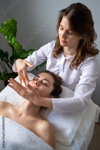 Beautician woman making lymphatic drainage face massage or facelifting massage at the beauty salon. Face Treatment. Beauty injection procedure for skincare.