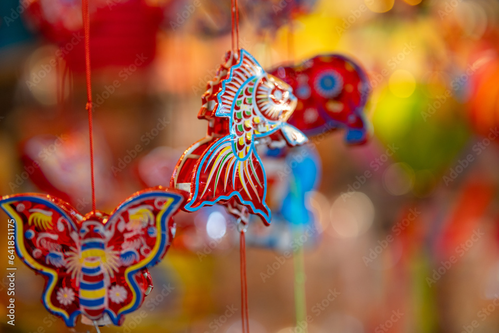 Decorated colorful lanterns hanging on a stand in the streets in Ho Chi Minh City, Vietnam during Mid Autumn Festival. Chinese language in photos mean money and happiness