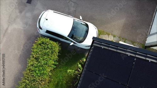 Drone flight over electric car charging with solar electricity from solar panels.