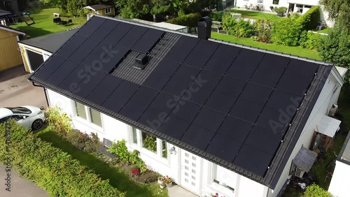 Drone circling over villa with solar panels and electric car charging